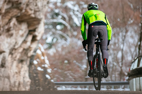 lange-fietsbroeken-met-zeem-man-fietsend-door-de-bergen-met-lange-fietsbroek-en-winter-fietsjas.png