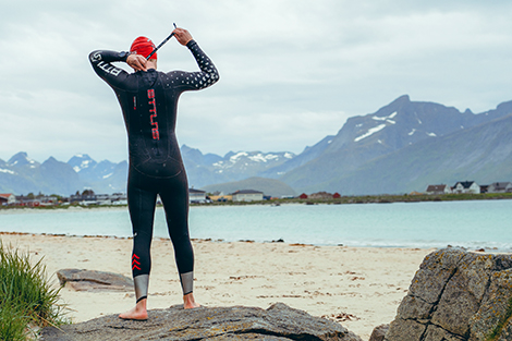 man-met-wetsuit-aan-en-badmuts-op-bij-openwater.jpg