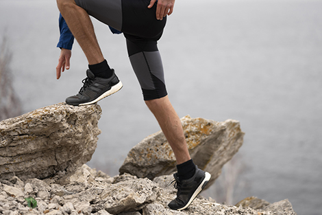 man-trail-running-over-stenen-met-hardloopschoenen-en-sokken.jpg