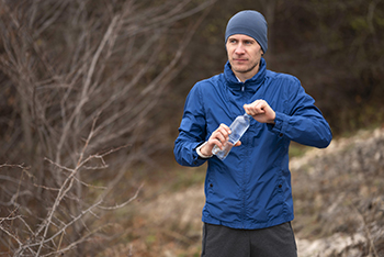 man-water-drinken-tijdens-hardloopsessie-in-bos.jpg