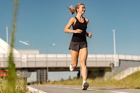 vrouw-hardlopend-in-zomer-over-de-weg.jpg