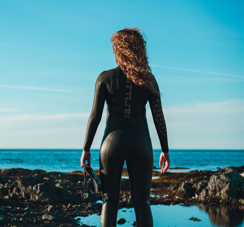 vrouw-in-wetsuit-bij-zee.jpg